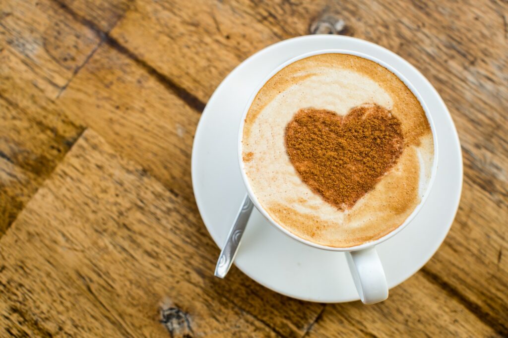 Loving coffee. Cup of fresh cappuccino with heart sign